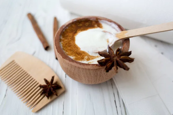 White substance in wooden cup with cinnamon and spices. — Stock Photo, Image
