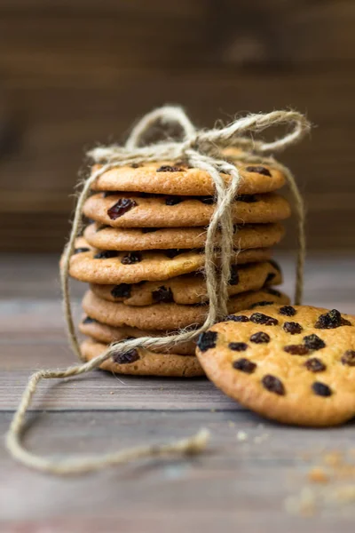 Honey cookies with raisins and milk on wooden table