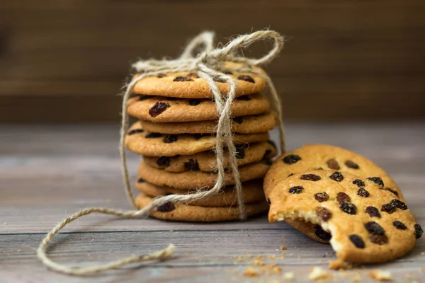 Honey cookies with raisins and milk on wooden table
