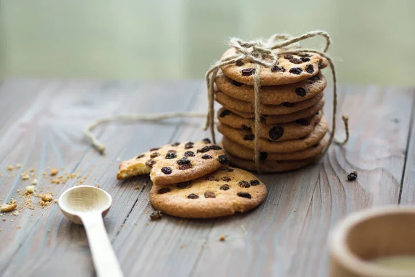 Honey cookies with raisins and milk on wooden table