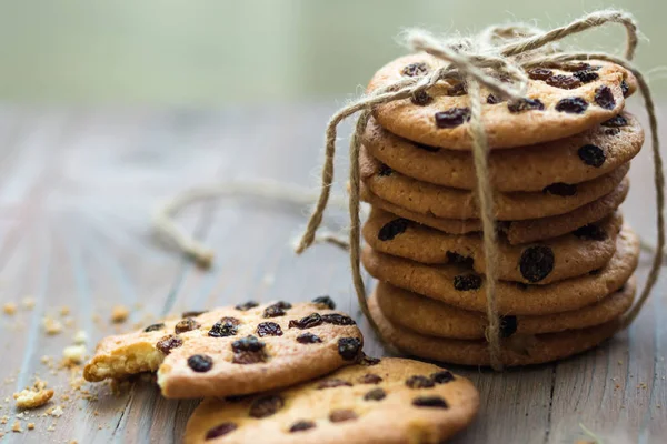 Honey cookies with raisins and milk on wooden table