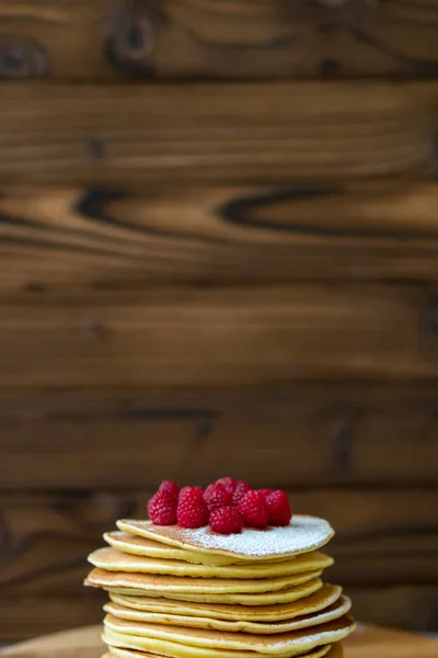 Tasty homemade pancakes with cream and raspberry. On wooden table. — Stock Photo, Image