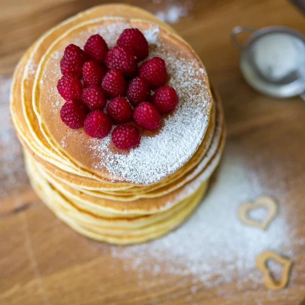 Tasty homemade pancakes with cream and raspberry. On wooden table. — Stock Photo, Image