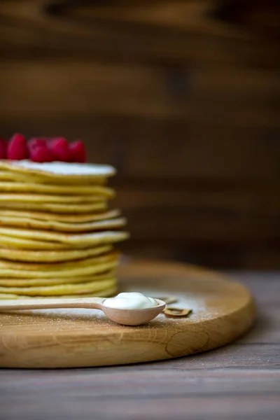 Tasty homemade pancakes with cream and raspberry. On wooden table. — Stock Photo, Image