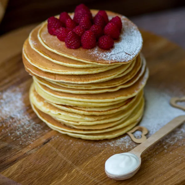 Panquecas caseiras saborosas com creme e framboesa. Na mesa de madeira . — Fotografia de Stock