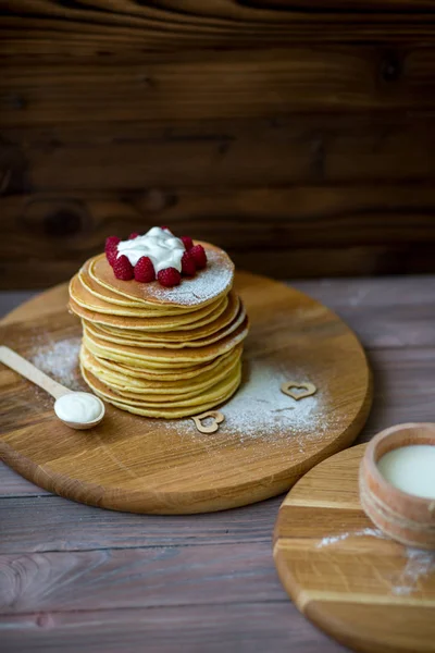 Panquecas caseiras saborosas com creme e framboesa. Na mesa de madeira . — Fotografia de Stock