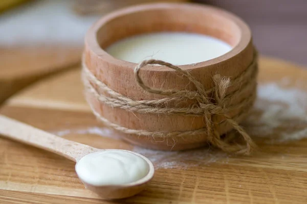 Ahşap bardak süt. Ev yapımı krem kaşıkla. 