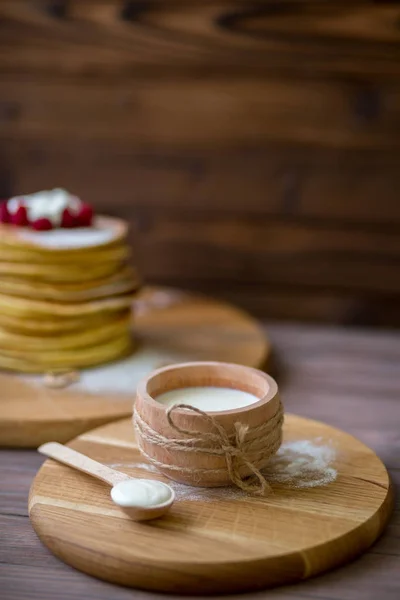 Leite em xícara de madeira. Colher com creme caseiro . — Fotografia de Stock