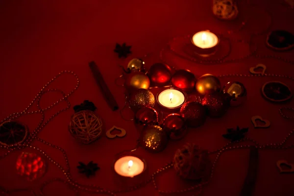 Golden and red balls on the red background. Candles in decorations. — Stock Photo, Image