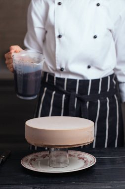 Kremalı kekin üzerine çikolata sosu dök.