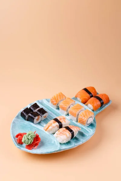 Rotoli e sushi su un piatto sotto forma di pesce — Foto Stock