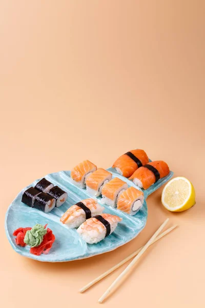 Rolos e sushi em uma chapa na forma de peixe — Fotografia de Stock