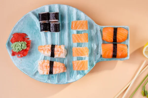 Rolos e sushi em uma chapa na forma de peixe Imagem De Stock