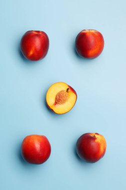 Mavi arka planda birkaç olgun kırmızı nektarin.