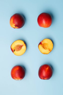 Mavi arka planda birkaç olgun kırmızı nektarin.