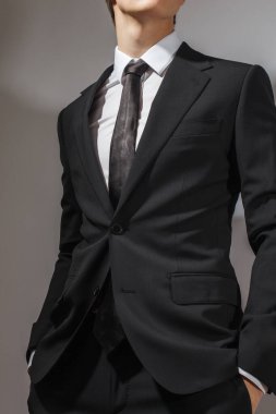 Siyah takım elbiseli ve beyaz kravatlı bir adam.