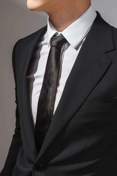 一个穿着黑色西服和白衬衫 打着黑领带的男人 — 图库照片