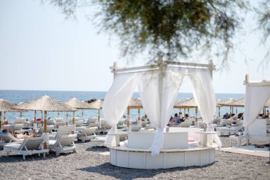 Kamari, Santorini, Yunanistan 'ın Kara Kumsalındaki Şemsiyeler