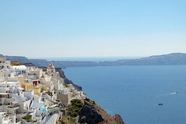 Beautiful view with traditional white buildings over the village of Oia at the Island Santorini, Greece