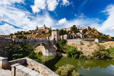 Güneşli bir yaz gününde Toledo İspanya 'nın panoramik manzarası. Antik taş duvarlar ve evler, mavi gökyüzü ve sıcak toprak.