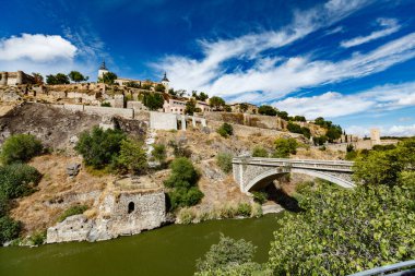 Güneşli bir yaz gününde Toledo İspanya 'nın panoramik manzarası. Antik taş duvarlar ve evler, mavi gökyüzü ve sıcak toprak.