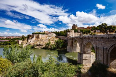Güneşli bir yaz gününde Toledo İspanya 'nın panoramik manzarası. Antik taş duvarlar ve evler, mavi gökyüzü ve sıcak toprak.