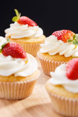 Çilekli kapkek, zeytin tahtasında karton bir kutunun içinde.