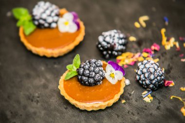 Tatlı tatlılar taze böğürtlenli ve lezzetli kremalı. Yakın çekim.