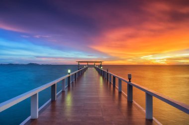 Wooden pier between sunset clipart