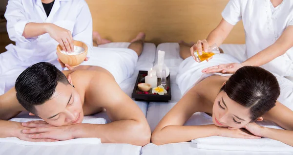 Jovem casal deitado na mesa de massagem e sorrindo — Fotografia de Stock