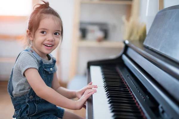 Küçük kız piyano oynamak ve oturma odasında bir şarkı — Stok fotoğraf
