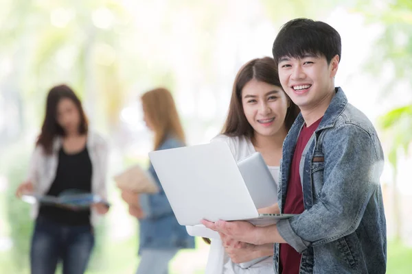 Студенты-азиаты в университете используют ноутбук — стоковое фото