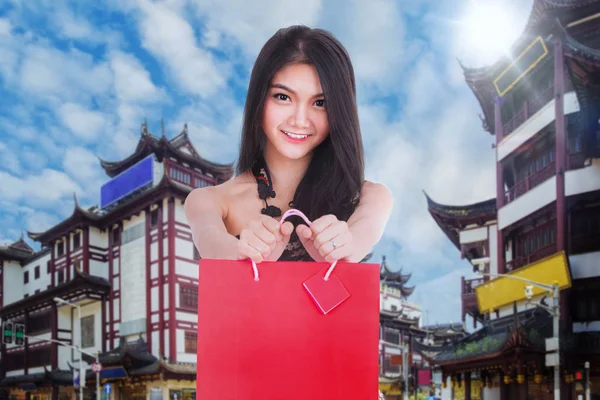 中国女人穿着旗袍衣裙提着购物袋 — 图库照片