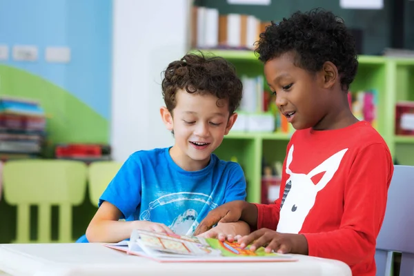 Schüler im internationalen Vorschulalter lesen gemeinsam ein Zeitschriftenbuch — Stockfoto