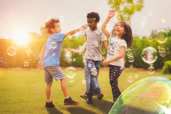 Kid och vänner i internationella förskola spelar en bubbla i pla — Stockfoto