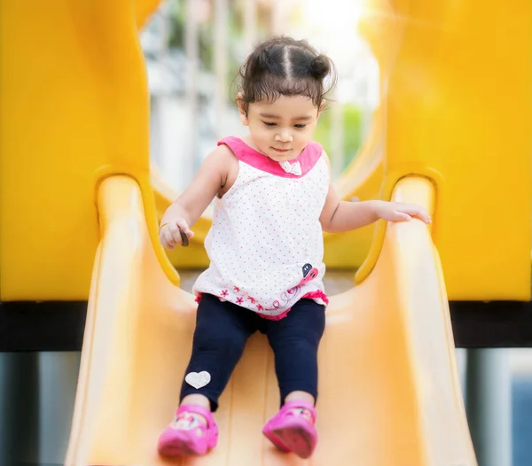 Menina asiática jogar um controle deslizante em Playground — Fotografia de Stock