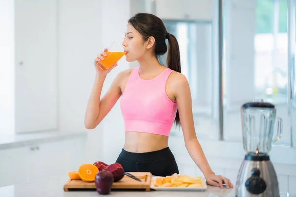 Азиатская женщина в фитнес-спорте носить напиток смесь фруктов и овощей — стоковое фото