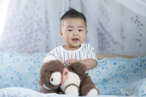 Asiatische Baby spielen einen Teddybär — Stockfoto