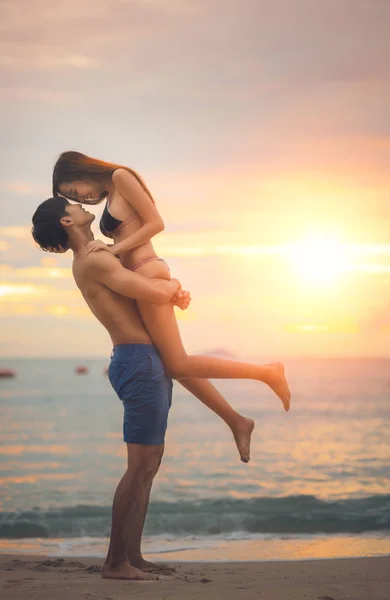 Asian couple run togather on the beach between honeymoon