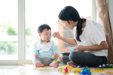 Tarafından mavi kaşık bir bebek besleme Mothe