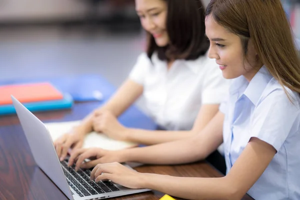 Asian student in Thai university MSke una tarea en la biblioteca — Foto de Stock