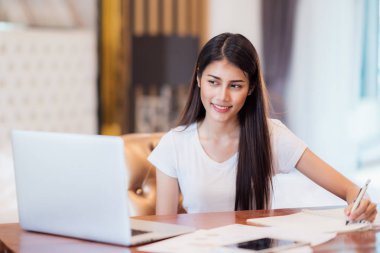 Asya Bayan öğrenci yapmak bilgisayar notebo ile masa üzerinde ev iş