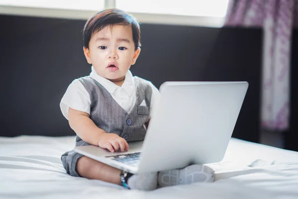 Asiatisches Baby in Business-Suite sitzt und spielt Computer-Notebook — Stockfoto