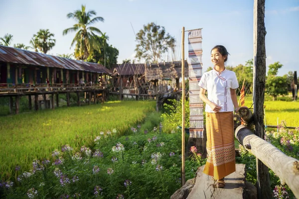 Тайская девушка ходит по рисовой ферме в тканой чашке из ламдуанской ткани — стоковое фото