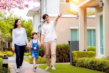 eautiful family portrait smiling outside their new house with su