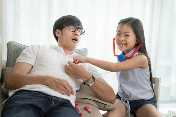 Asiatische Mädchen und Ihr Vater spielen tocollect für Arzt job — Stockfoto