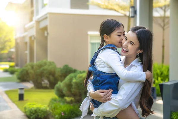 Moeder en haar smerige spel te verzamelen in de voorkant van haar huis — Stockfoto