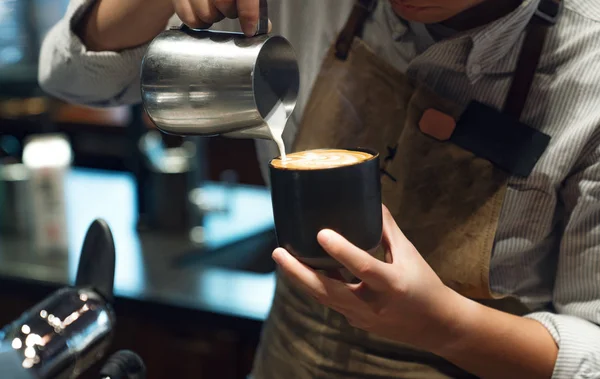 Closeup image of male barista holding and pouring milk for prepa — Stock Photo, Image
