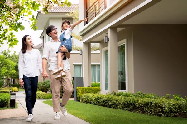 Vackra familjeporträtt leende utanför deras nya hus — Stockfoto