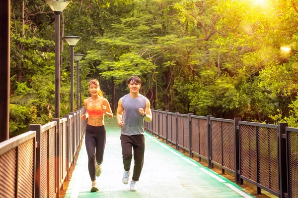 Man en meisje rennen te verzamelen in het park in Bangkok stad — Stockfoto